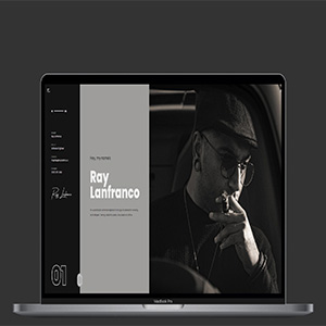 A photo of a MacBook Pro displaying a shot from the RayLanfran.co website.